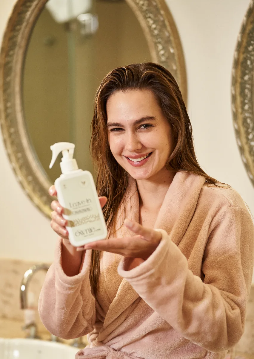 Mulher segurando o Leave-in Ownie Care após o banho